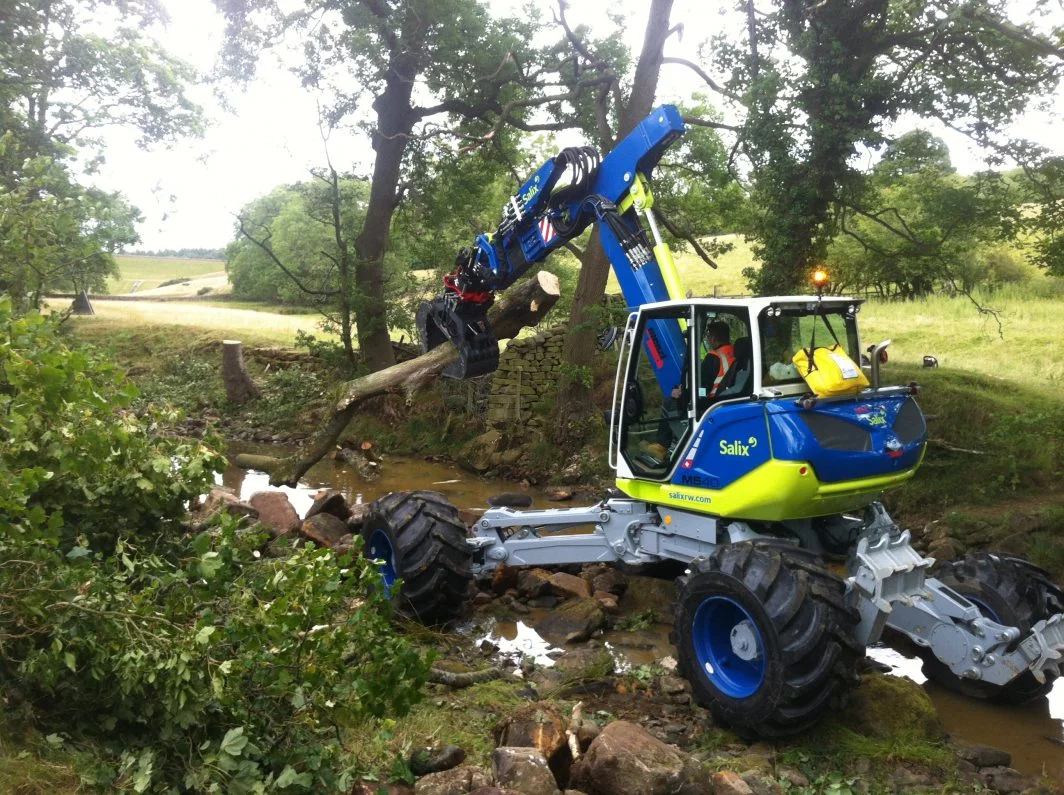Spider Menzi Muck Excavator moving large woody debris below Swinsty Reservoir