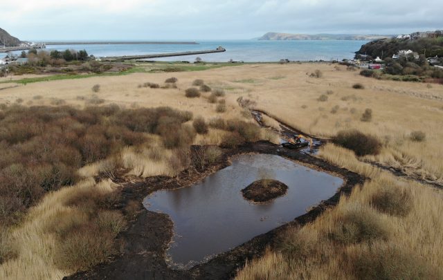 Open pond with sea view on Goodwick Moor in Pembrokeshire, opened up wetland offers habitat to a range of wildlife. Our amphibious machinery is on site