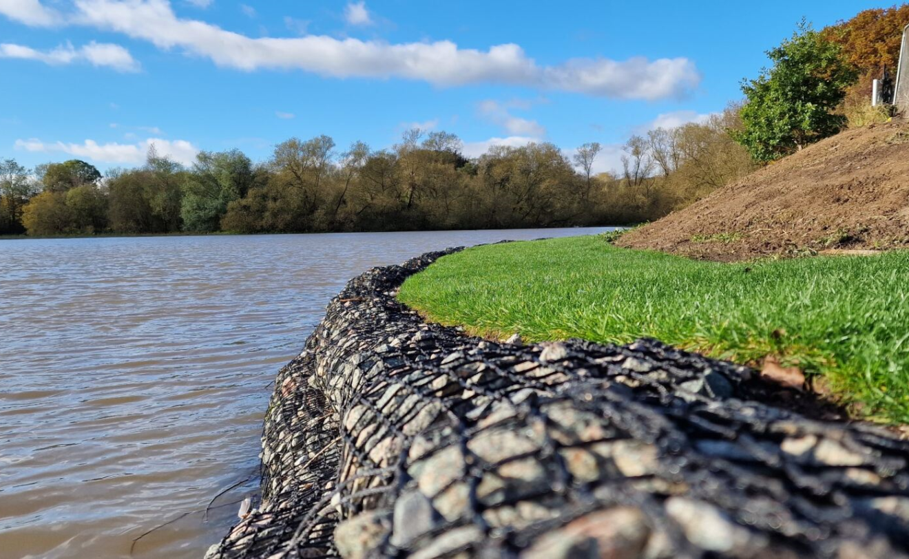 rock mattresses installed on endge of reservoir with grass seeded top of bank